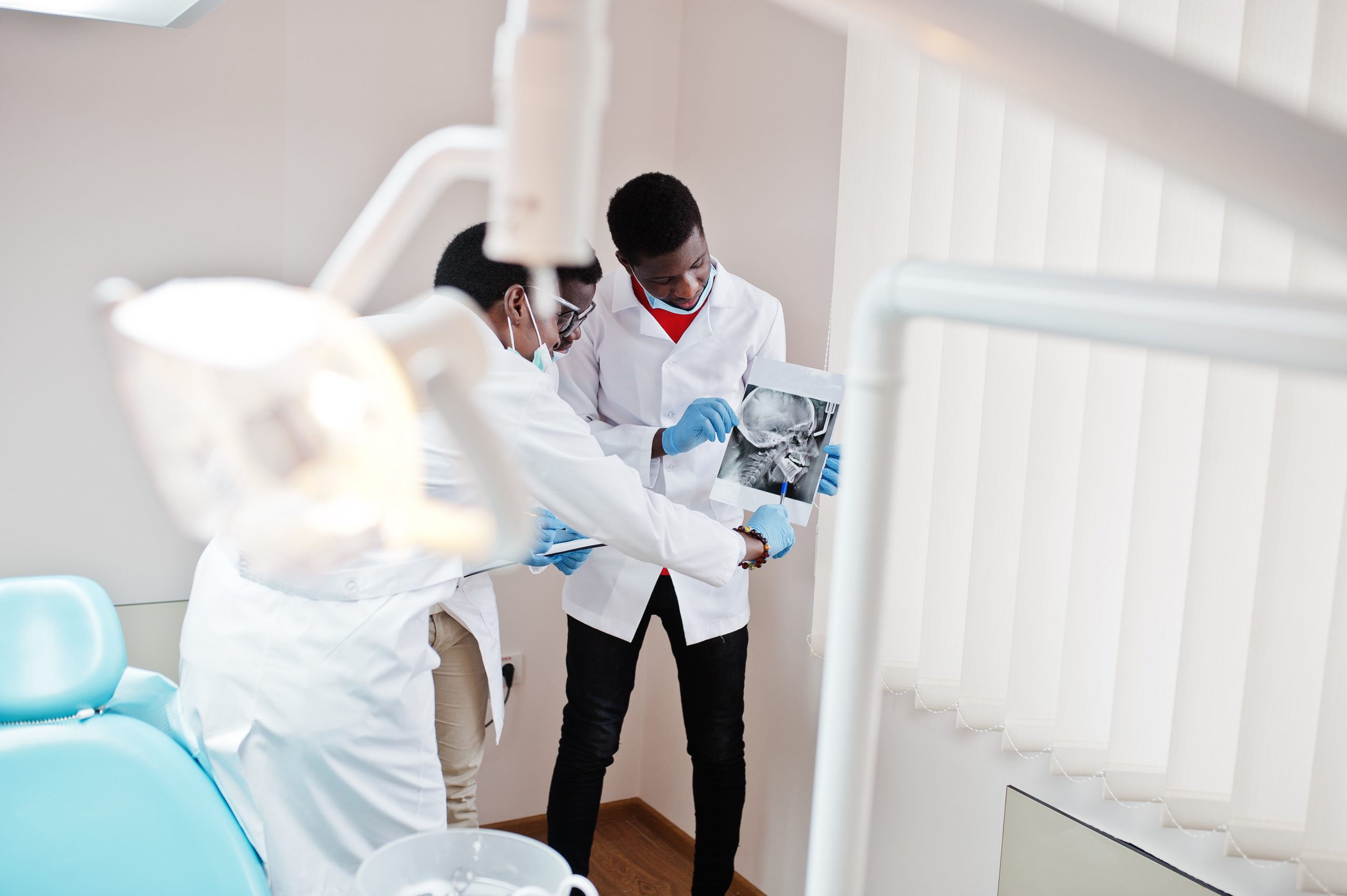 Three african american male doctors working, discussing with col